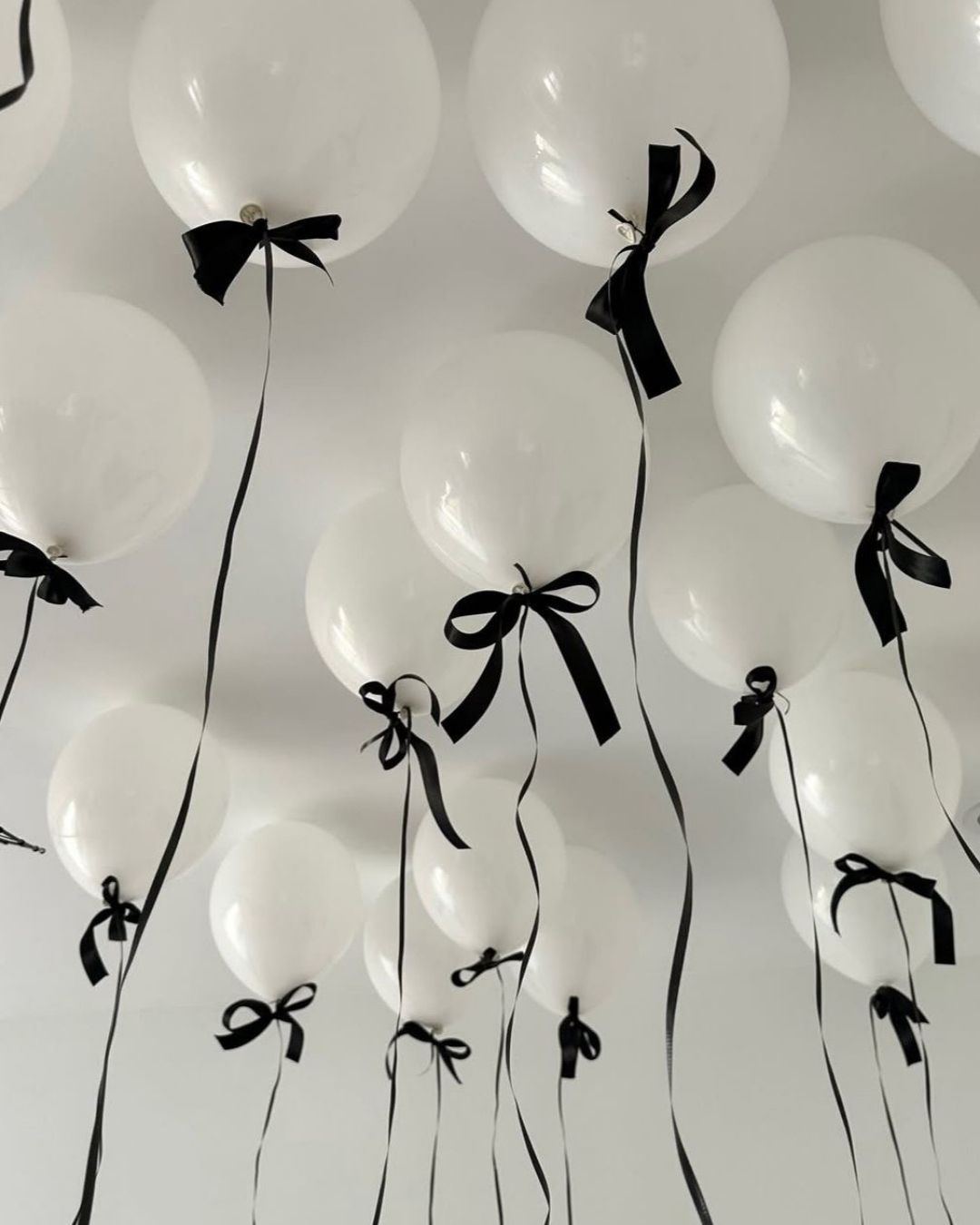 Palloncini bianchi con fiocchi neri per un allestimento di festa